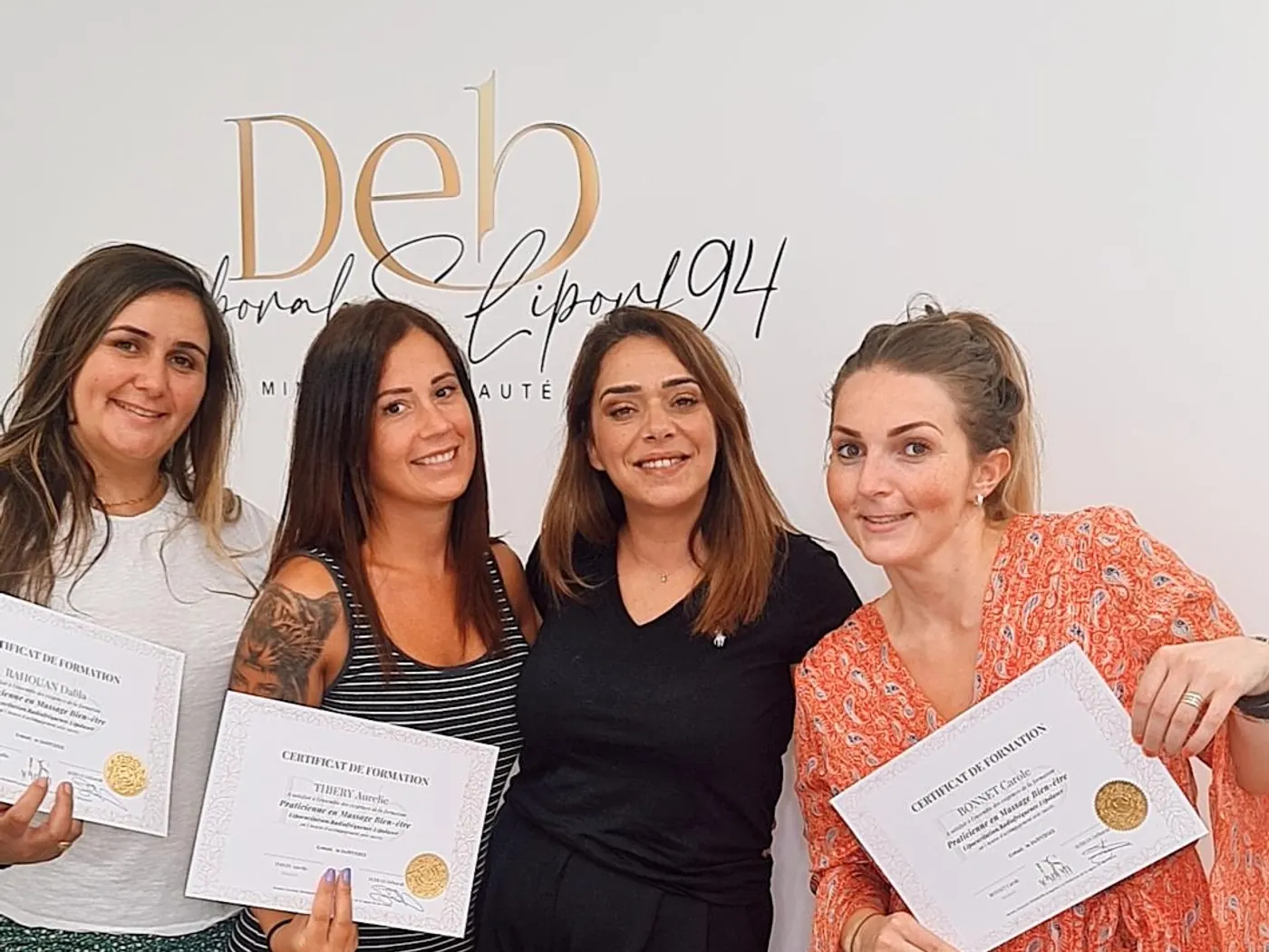 Quatre femmes présentent leurs attestations devant le lettrage doré du centre.